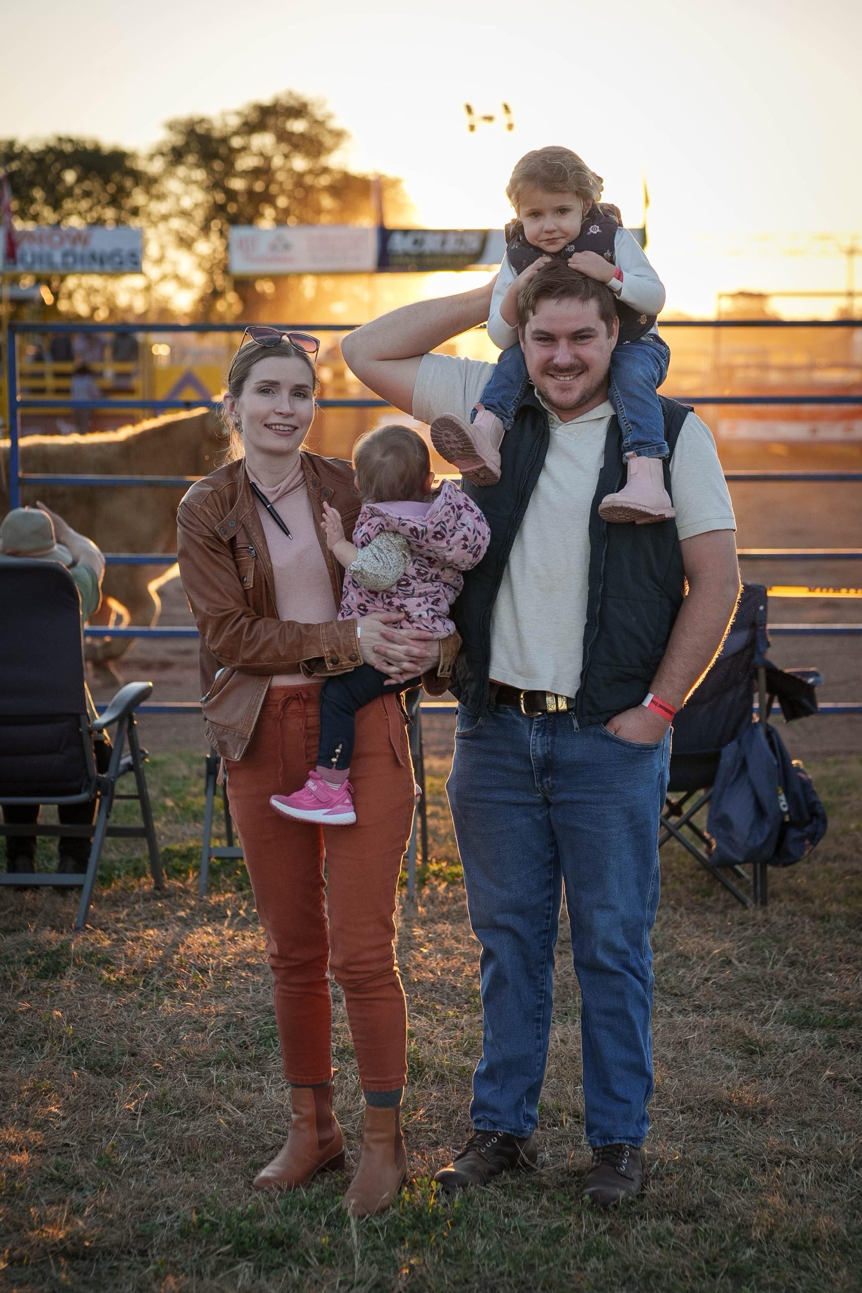 A man and a woman lovingly hold a child between them, showcasing a moment of family togetherness and affection.