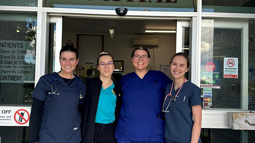 Four women in scrubs pose together in front of St. George Hospital, showcasing their dedication to healthcare.